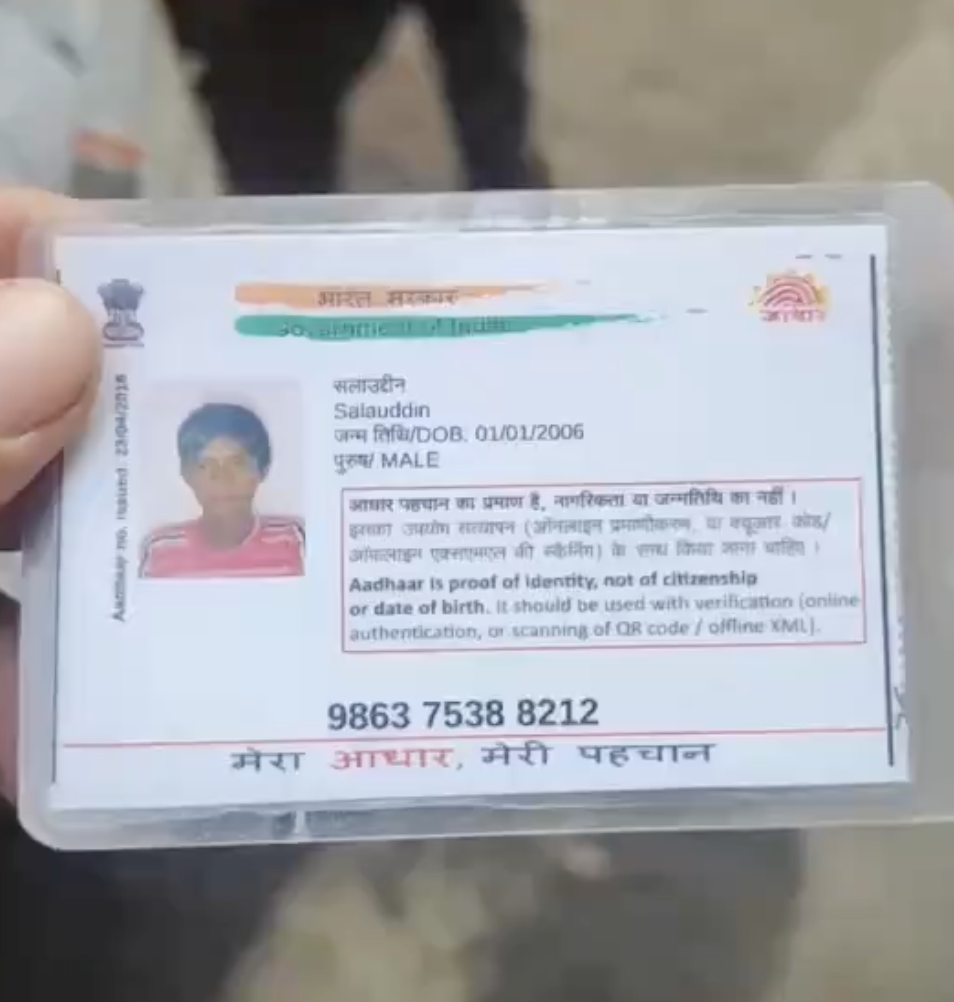 Far-right leader Raju Rawat checks the Aadhar card of a Muslim vendor